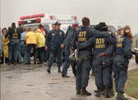 Alcohol, Tobacco and  Firearms agents comfort each other as emergency medical personnel  prepare to transport a wounded agent at the Mount Carmel compound.(AP)